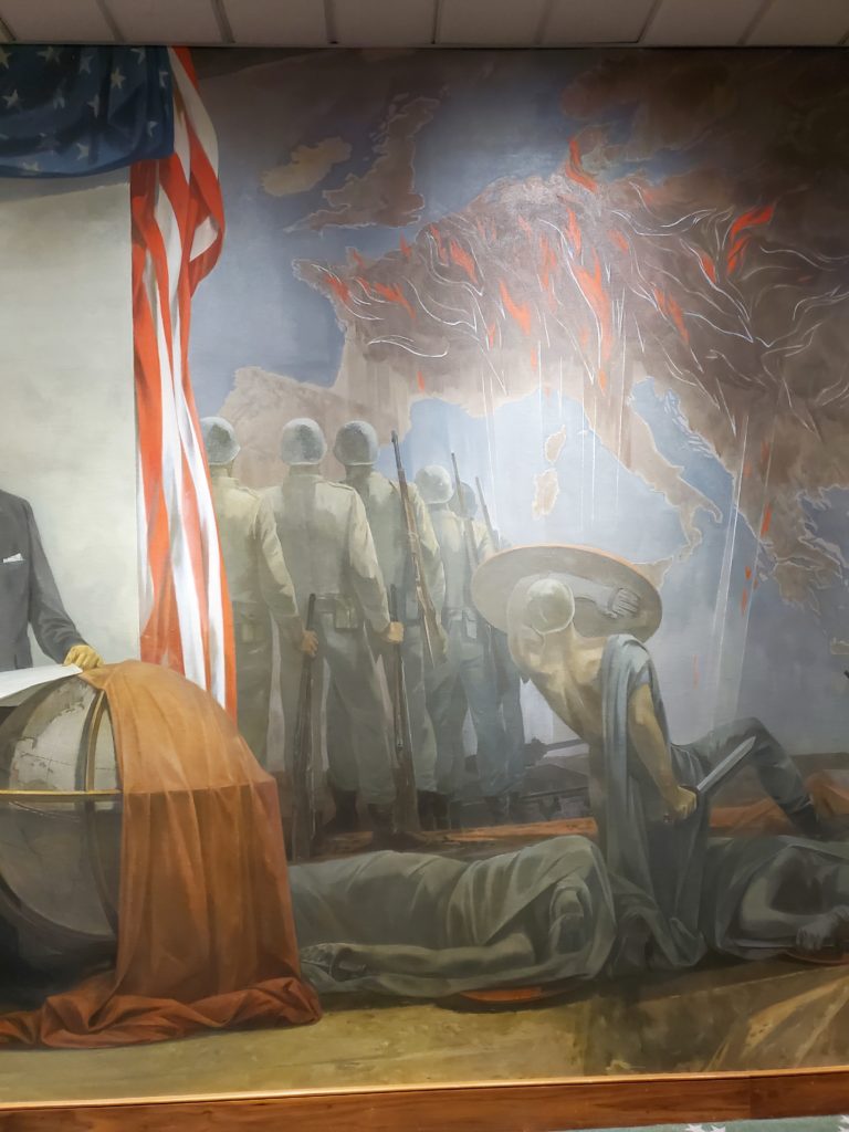 The people with swords and shields illustrate the army that General Marshall took over in 1939, and those marching off to war with helmets and rifles represent the new, well-equipped army.