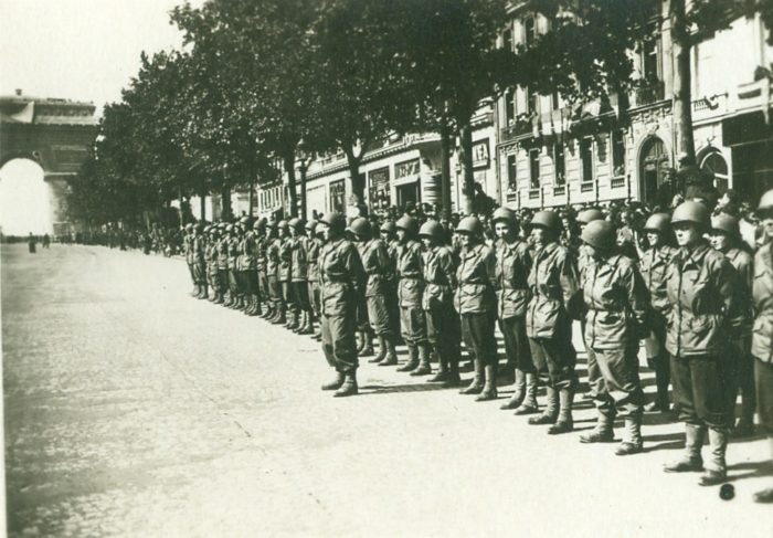 WAC personnel at the Arc de Triomphe in Paris during Remembrance Day ceremonies Nov. 11, 1944. While serving in Europe, WAC soldiers wore fatigues, boots, and helmets.