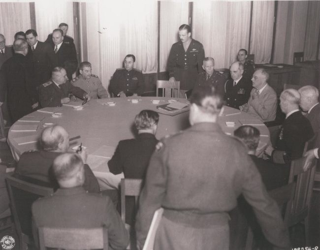 Prime Minister Churchill, Premier Stalin, Gen. Kuter, Gen. Marshall, Adm. Leahy, President Roosevelt, and Adm. King with others at a meeting.