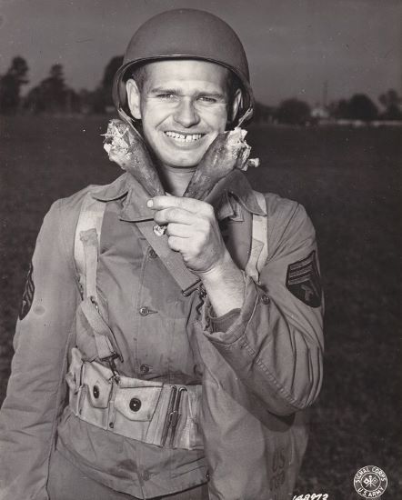 Sgt. Lewis Knaul of Columbus, OH, obliges with a "V" for Victory made of turkey drumsticks at which he gazes admiringly. He is with Camp Lee 1st Quartermaster salvage depot.