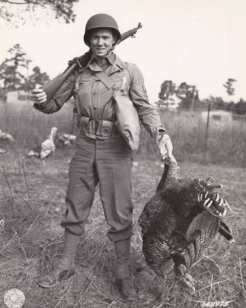 Tech. Sgt. L. J. Tholen of Ft. Wayne, IN, and now in Camp Lee's 1st Quartermasters Salvage Depot, strikes a pose as he catches his Thanksgiving turkey.